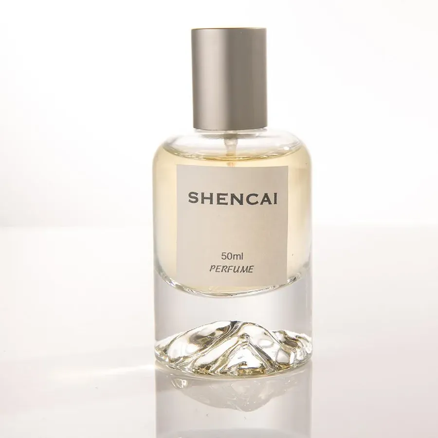 Clear glass eau de parfum bottle with a stone-textured base